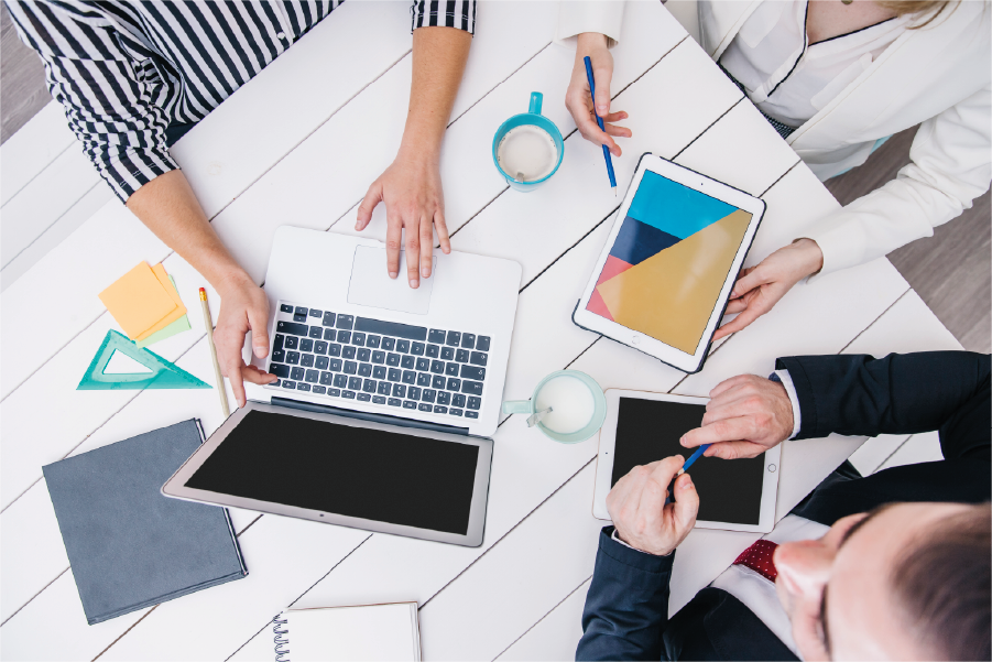 Team overlegt over een digitaal project met laptop en tablets